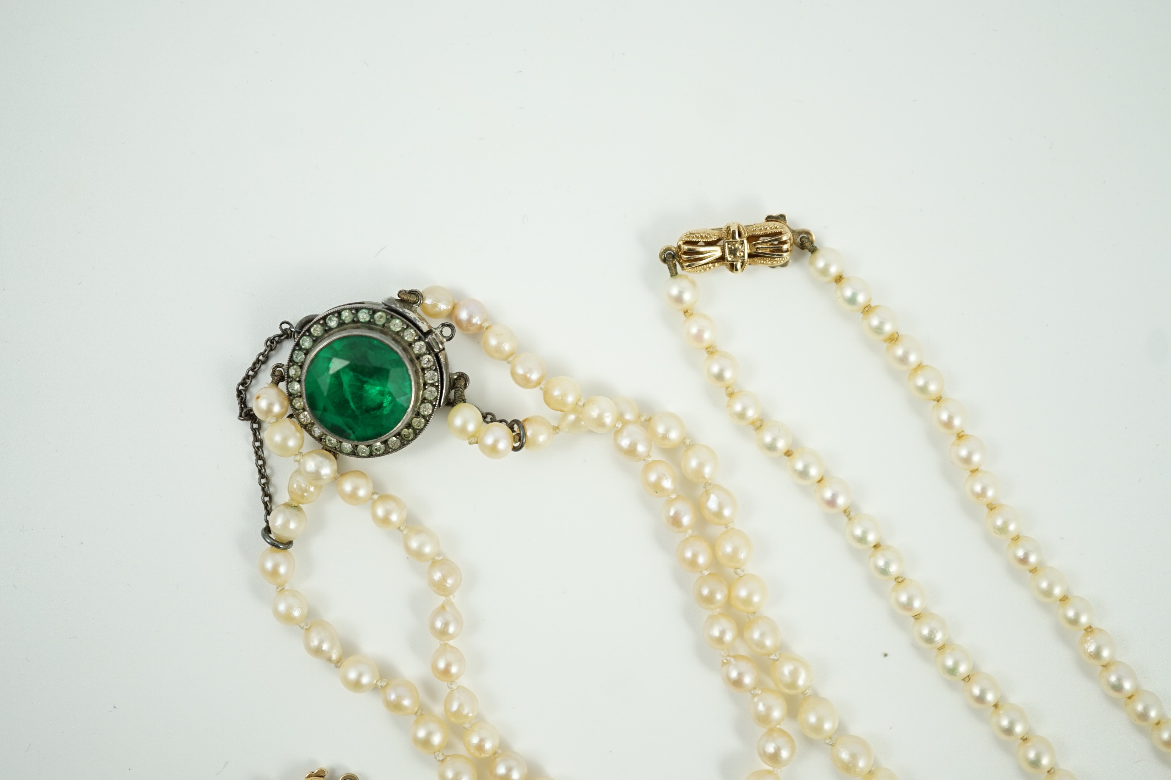 A twin strand graduated cultured pearl necklace, with white metal and two colour paste set clasp, 40cm, a single strand cultured pearl necklace, with 9ct gold clasp and a similar bracelet.